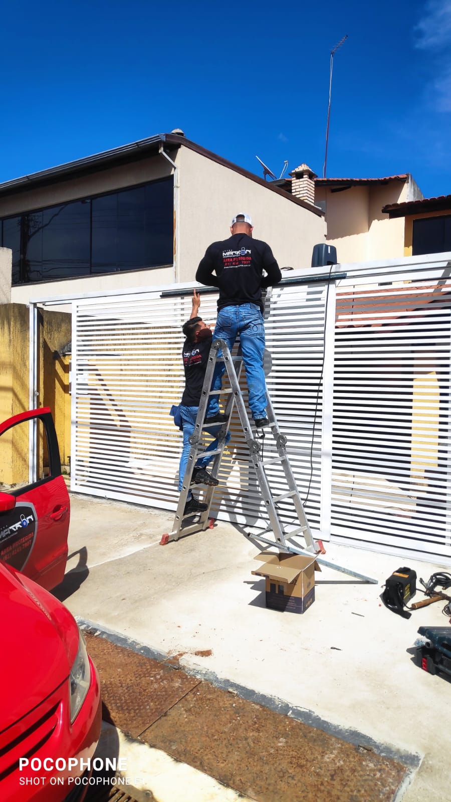 Equipe da Matron uniformizada instalando sistema de segurança em residência com escada e veículo da marca